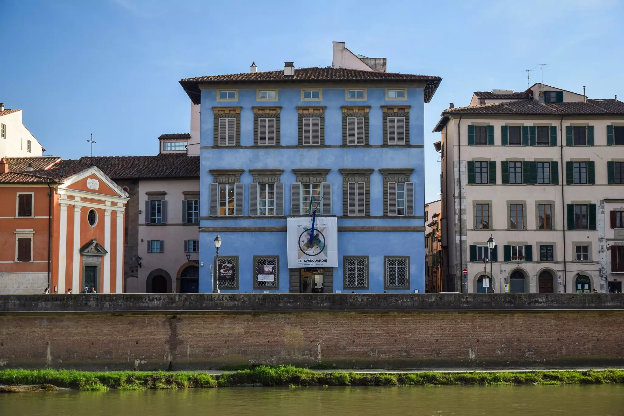 A blue-building housing a museum overlooking a river.
