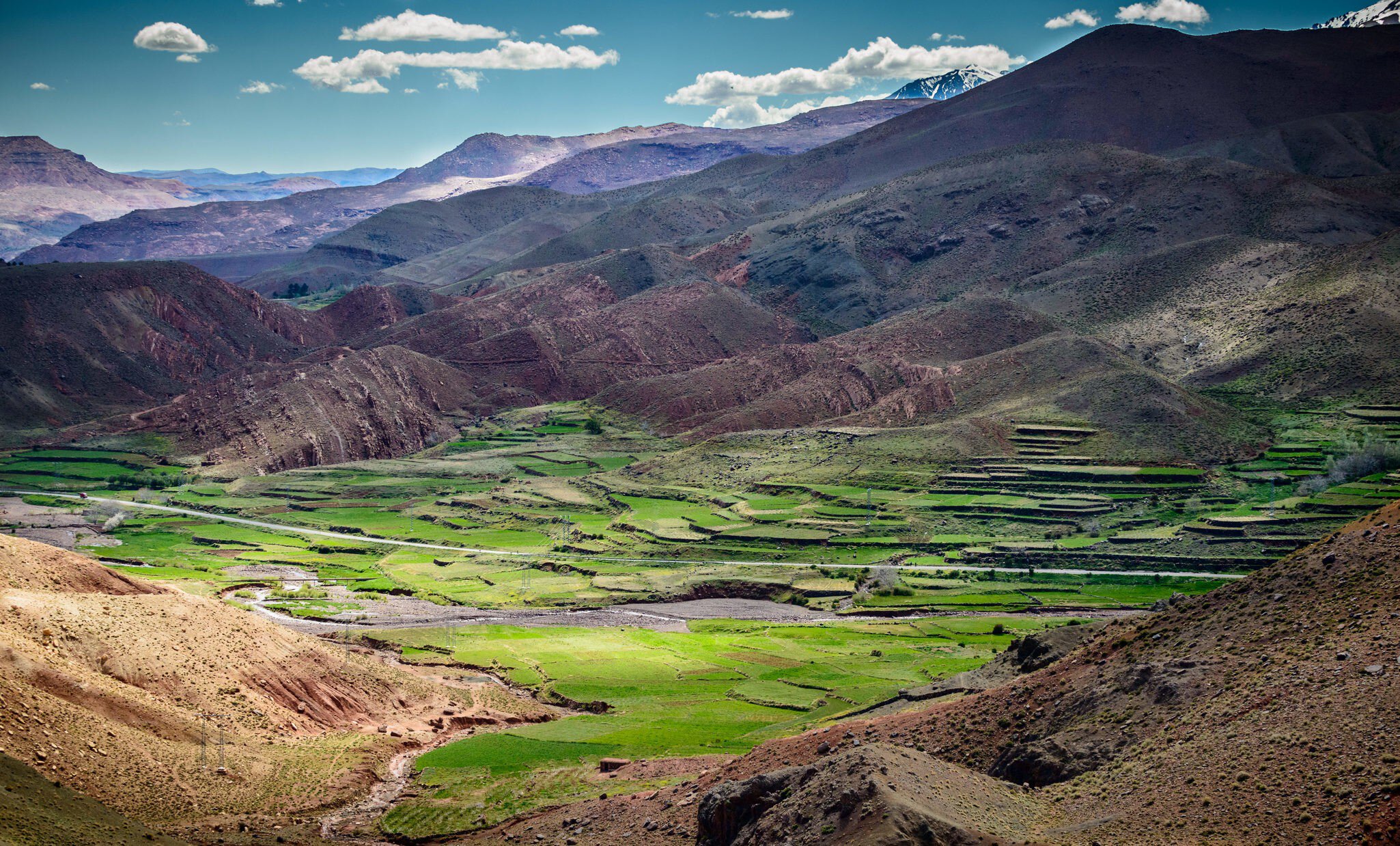 Green fields a valley surrounded by foothills on a sunny day.