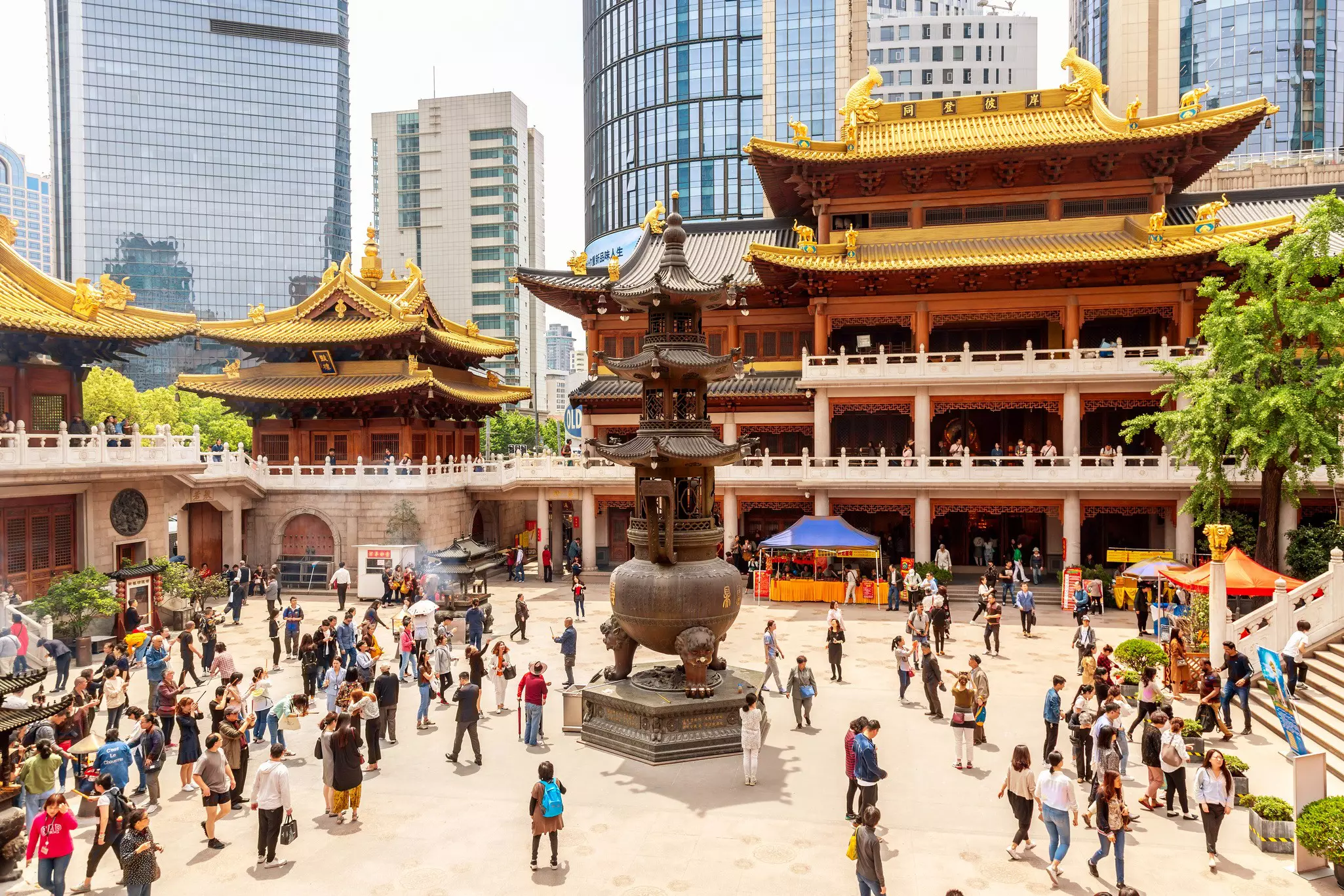Devotees and tourists stand in the courtyard at the Buddhist Jing'an Temple in Shanghai, China.
