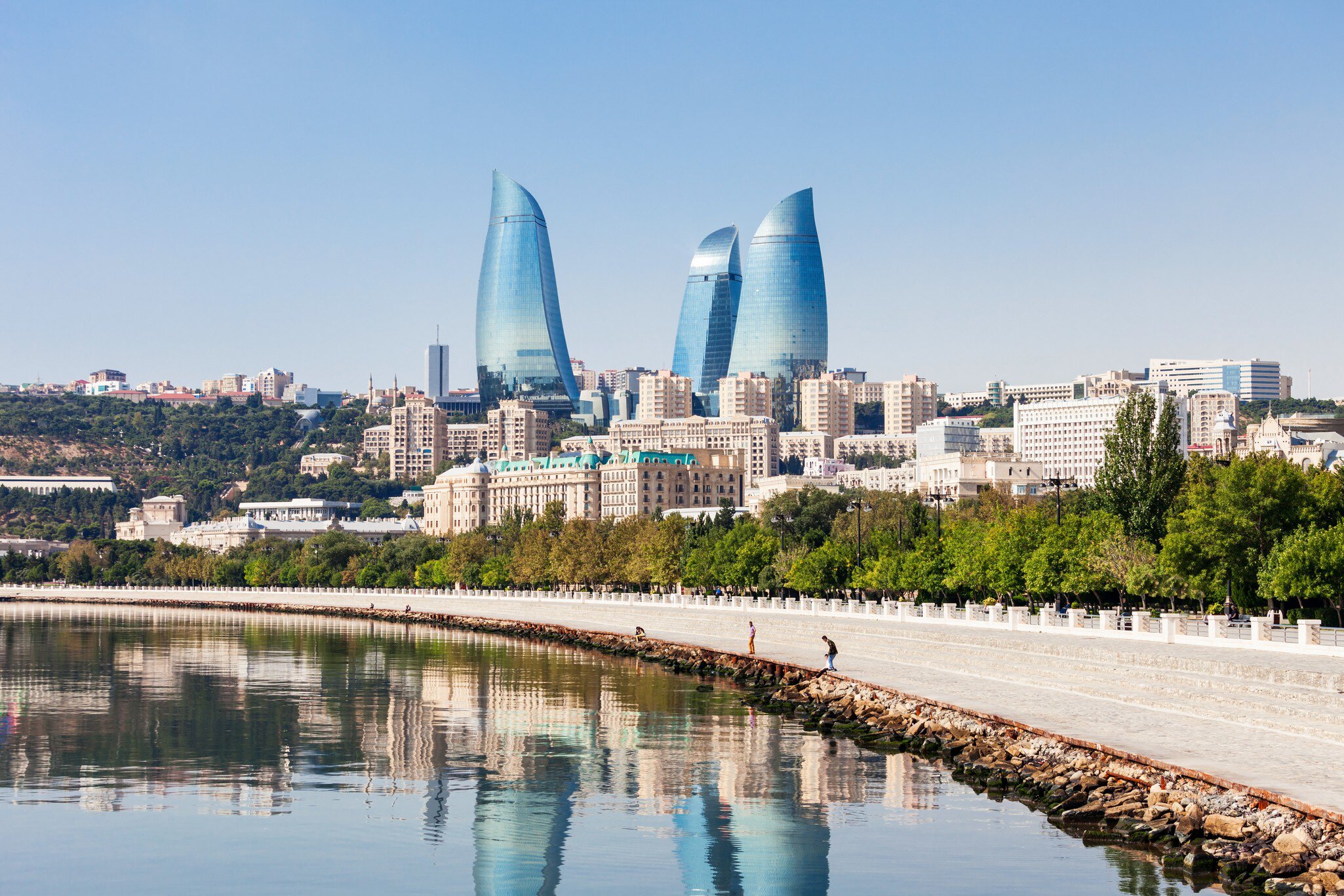 Wide angle view of the Flame Towers, the tallest skyscraper in Baku, Azerbaijan with a height of 190 m. Reflection of cityscape in the water.