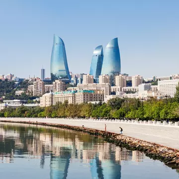 Wide angle view of the Flame Towers, the tallest skyscraper in Baku, Azerbaijan with a height of 190 m. Reflection of cityscape in the water.