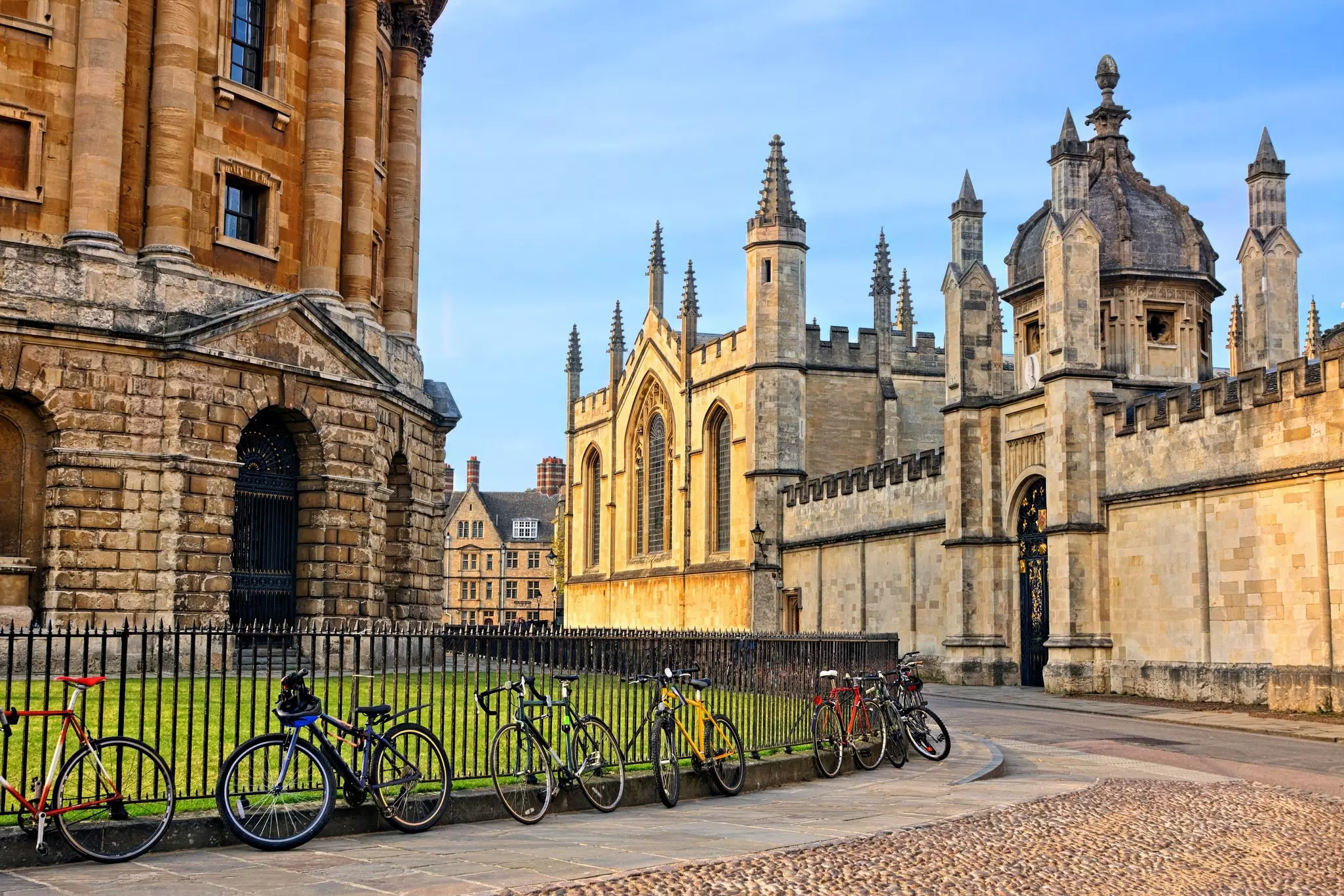 Oxford University at dusk, looking towards Radcliffe Camera and All Souls College with bicycles on cobblestone streets, Oxford, England.