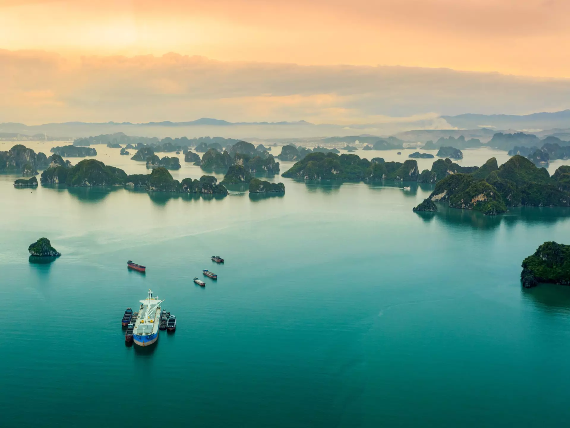 Many islets stretch into the distance of the ocean reflecting the sunlight, viewed from a seaplane