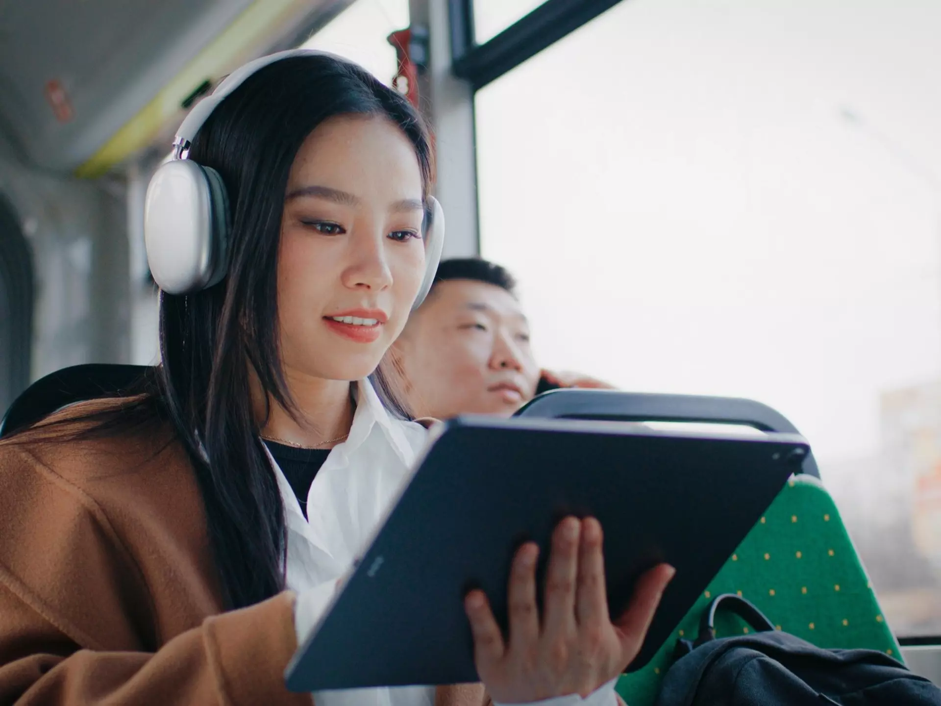 Young Chinese girl with long black hair using tablet with big screen. Navigating in device with one hand. Enjoying music in white headphones. Entertaining herself with digital devices., License Type: media, Download Time: 2025-03-10T19:53:47.000Z, User: dermothegarty77, Editorial: false, purchase_order: 56530 - Guidebooks, job: Global Publishing WIP, client: China 17 , other: Dermot Hegarty