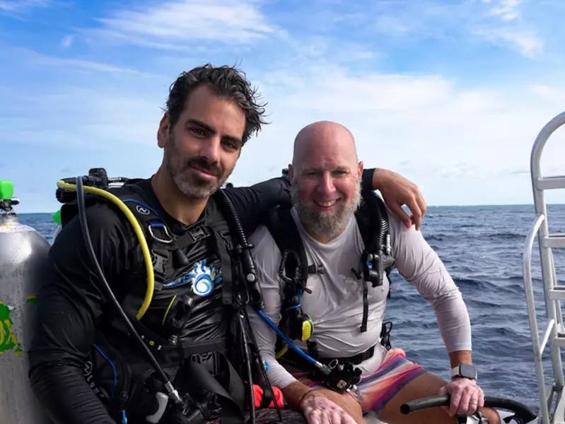 Two men on a boat in the ocean. 