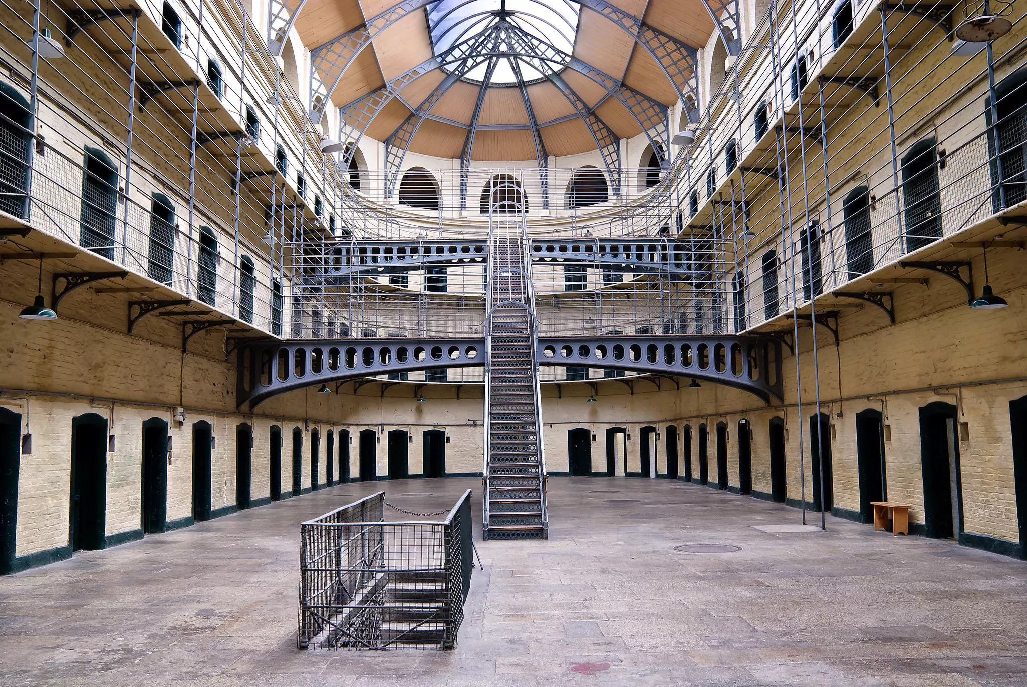 The inside of Kilmainham Gaol, a former prison, with a ladder going upward and two walking bridges