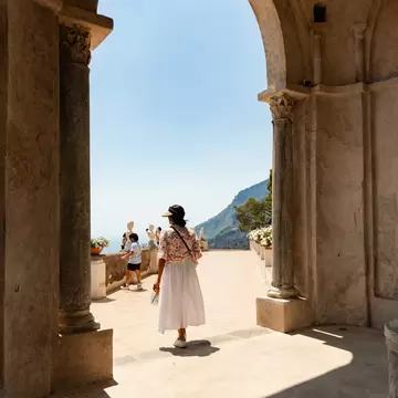 A person alone framed in an archway leading to a terrace.