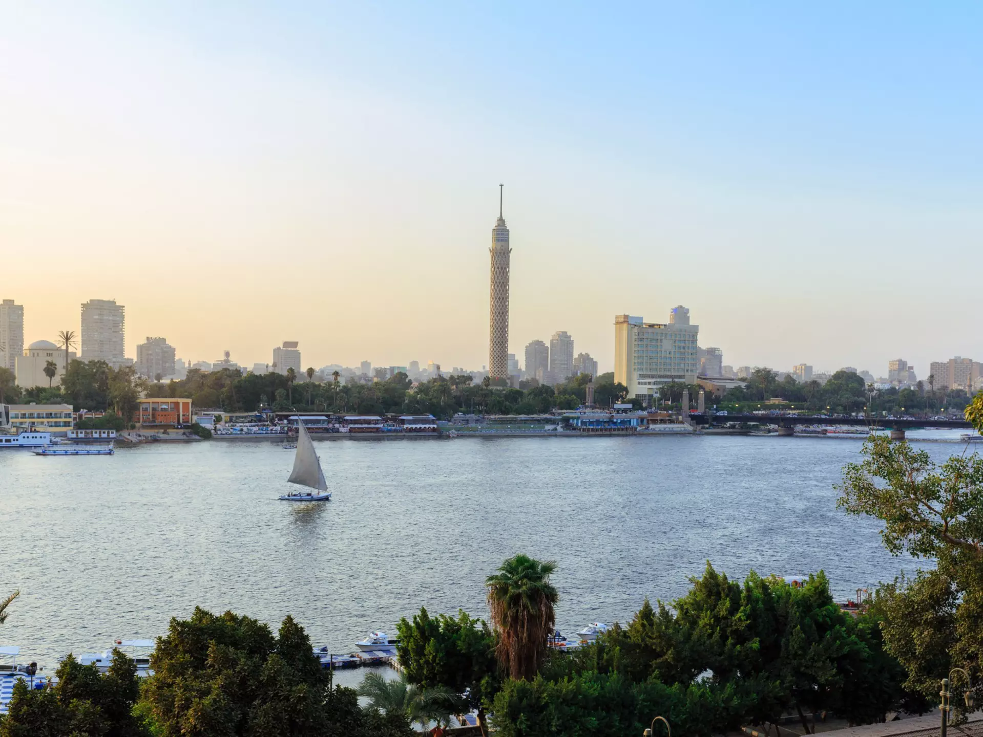 The Nile River weaving through the city of Cairo, with a few small sail boats