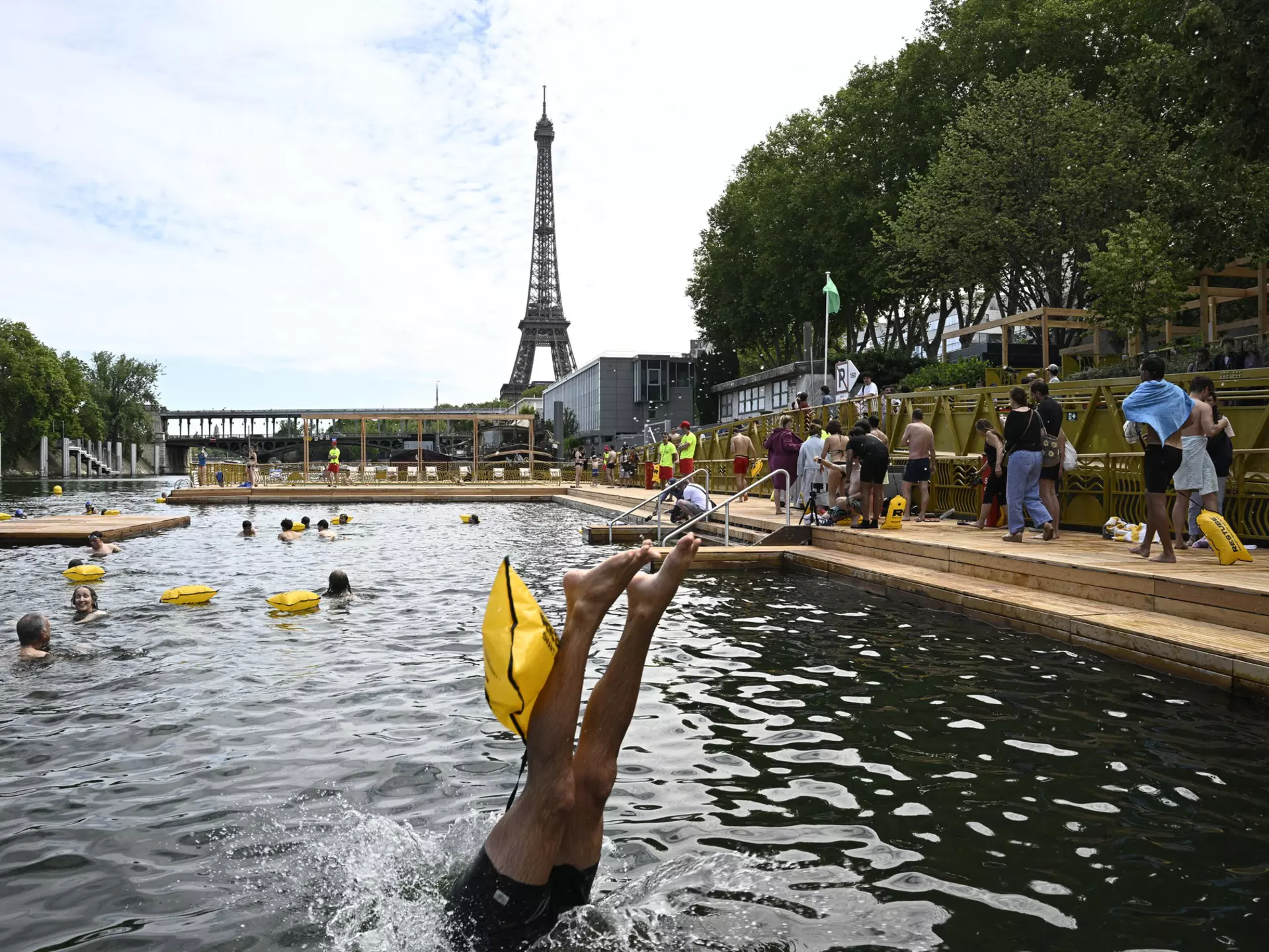 Families swimming in the River Seine in Paris, with the Eiffel Tower behind
