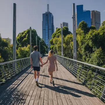 Young couple walking through Birrarung Marr in Melbourne, Australia.