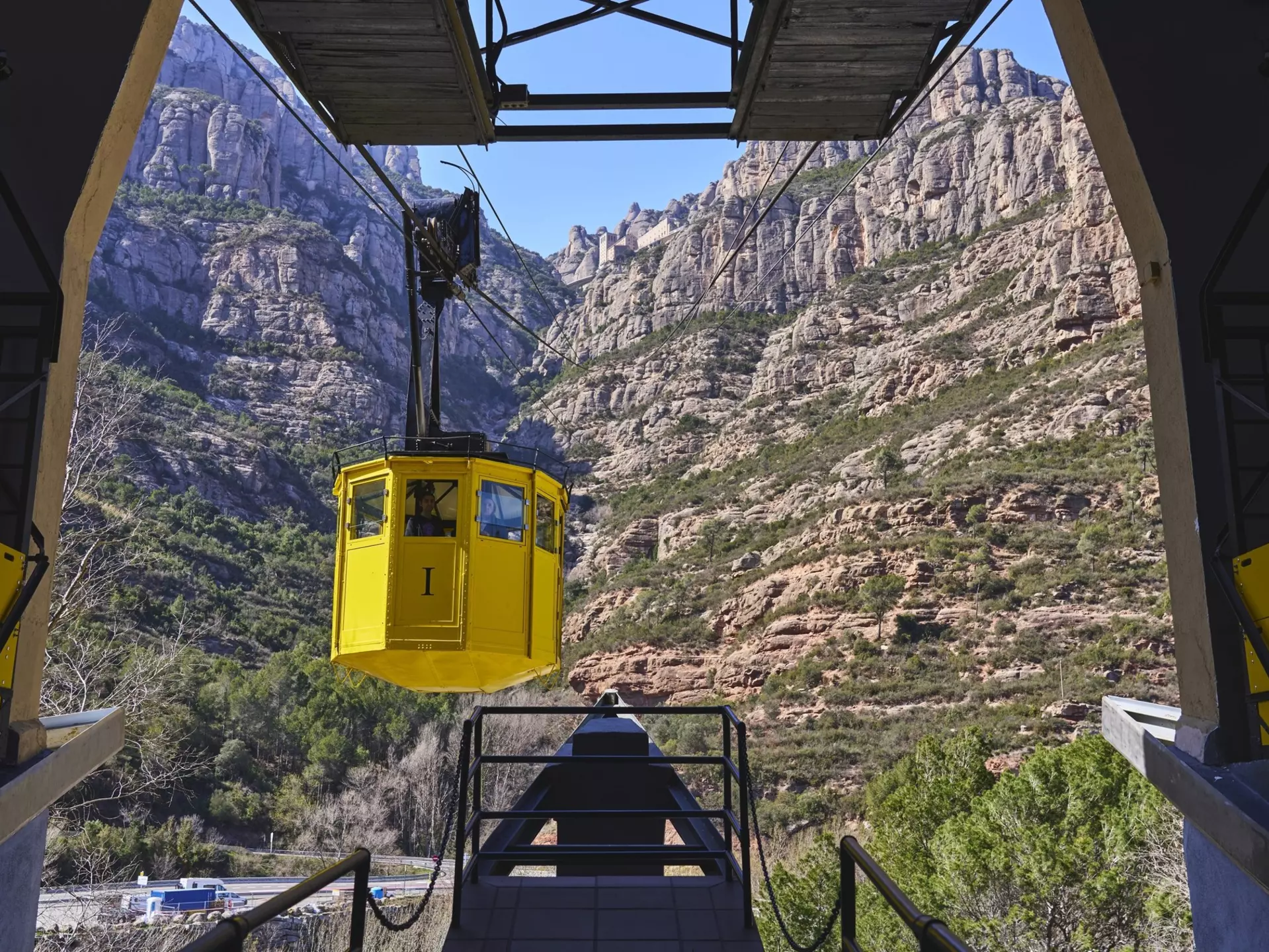View of a yellow cable car arriving at the station in Montserrat near Barcelona, Spain.