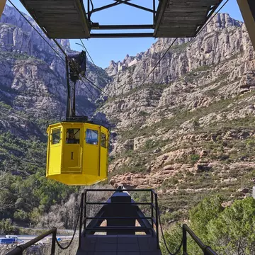 View of a yellow cable car arriving at the station in Montserrat near Barcelona, Spain.
