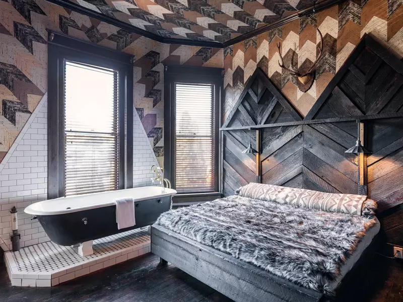 A western inspired room at Urban Cowboy. A bed next to a clawfoot tub.