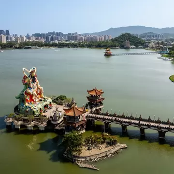 Aerial view of traditional of a statue and Chinese pavilions in a green pond in Kaohsiung, Taiwan.