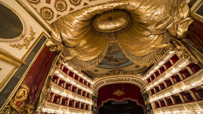 An ornate theater decorated in gold and red in Italy.