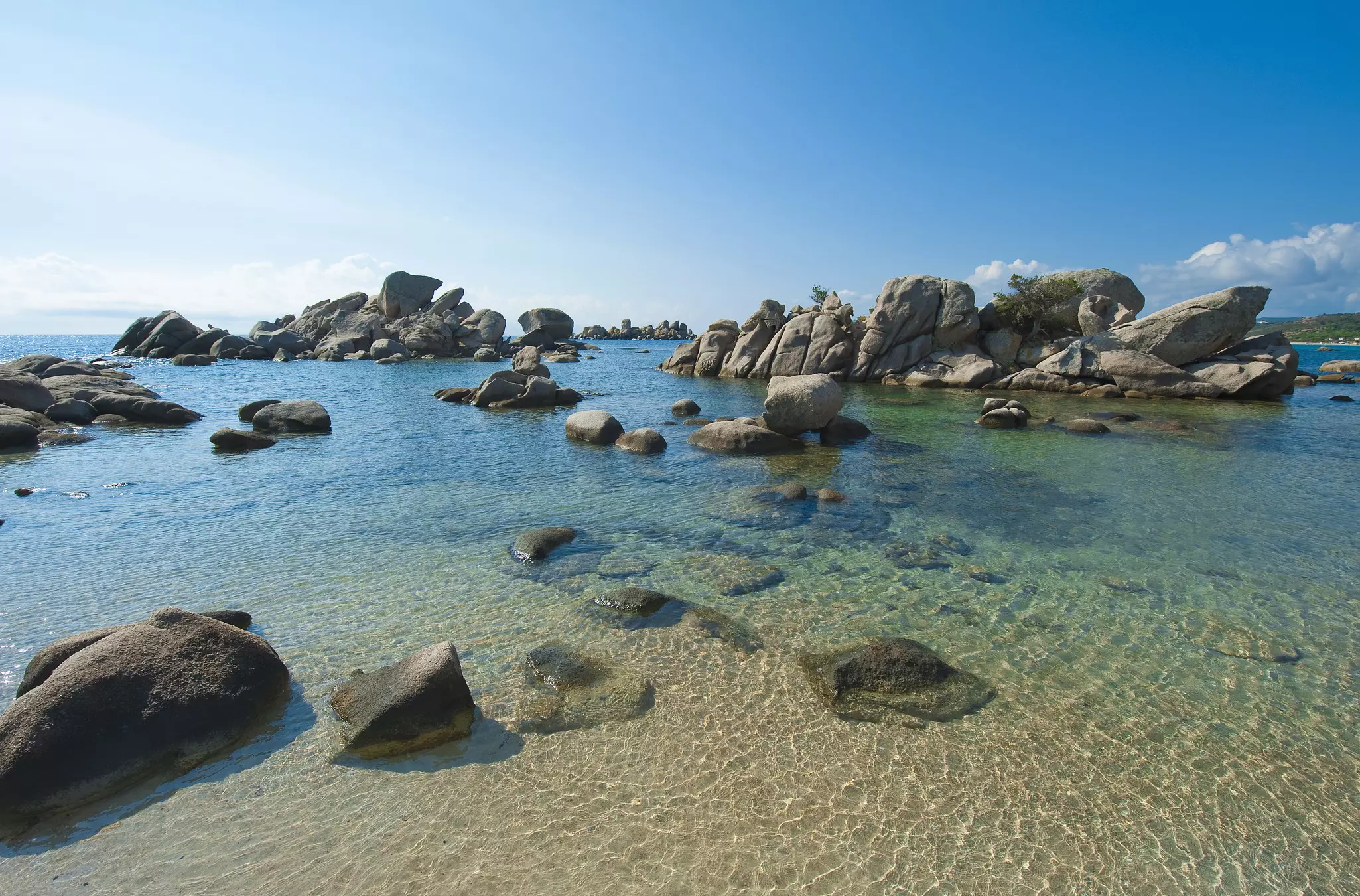 Rocks jutting out of the water at Palombaggia beach, Corsica.