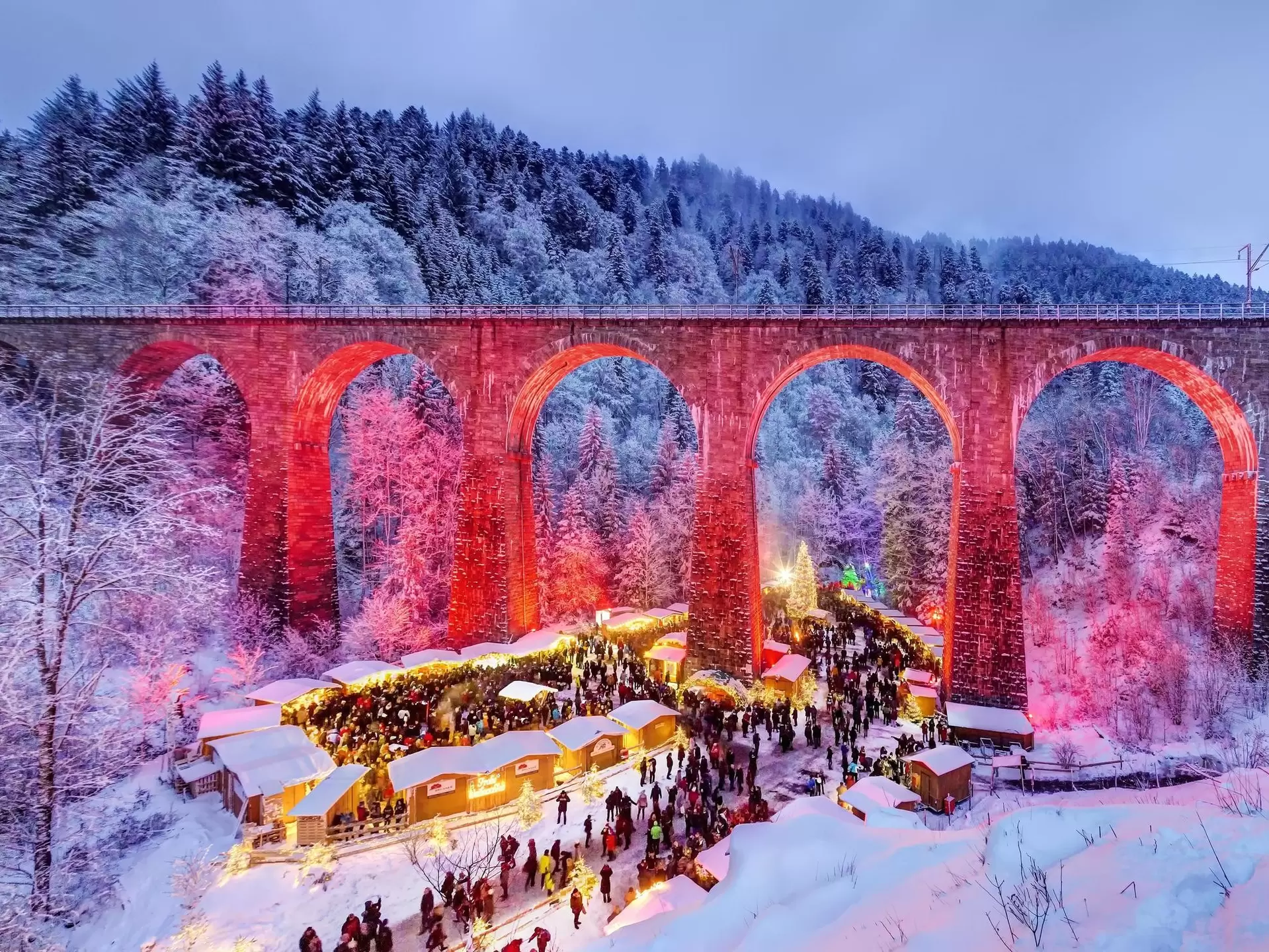 Christmas market in the Ravenna Gorge in the snowy Black Forest, the railway viaduct of the Hoellentalbahn is colourfully illuminated, Black Forest, Breitnau, Baden-Wuerttemberg, Germany