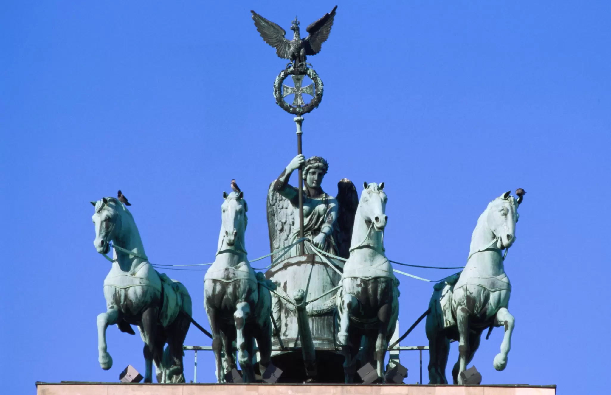The statue of four horses being driven (quadriga) crowns the Brandenburg Tor (gate) in Berlin, Germany.
