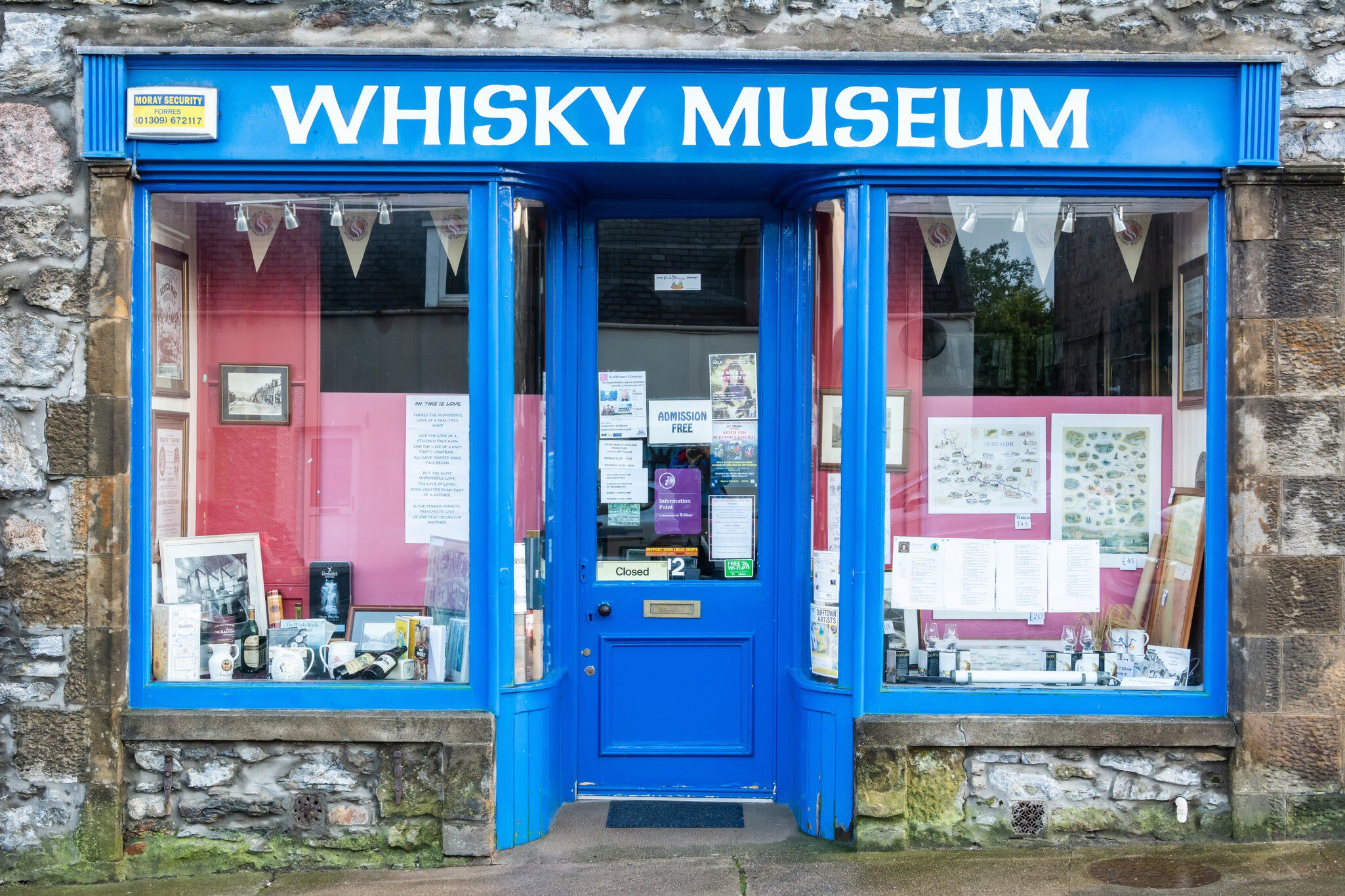 Blue-painted shopfront with WHISKY MUSEUM lettering and bottles in the window