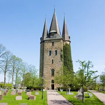 View of a church and graveyard in Husaby on a sunny day in Sweden.
