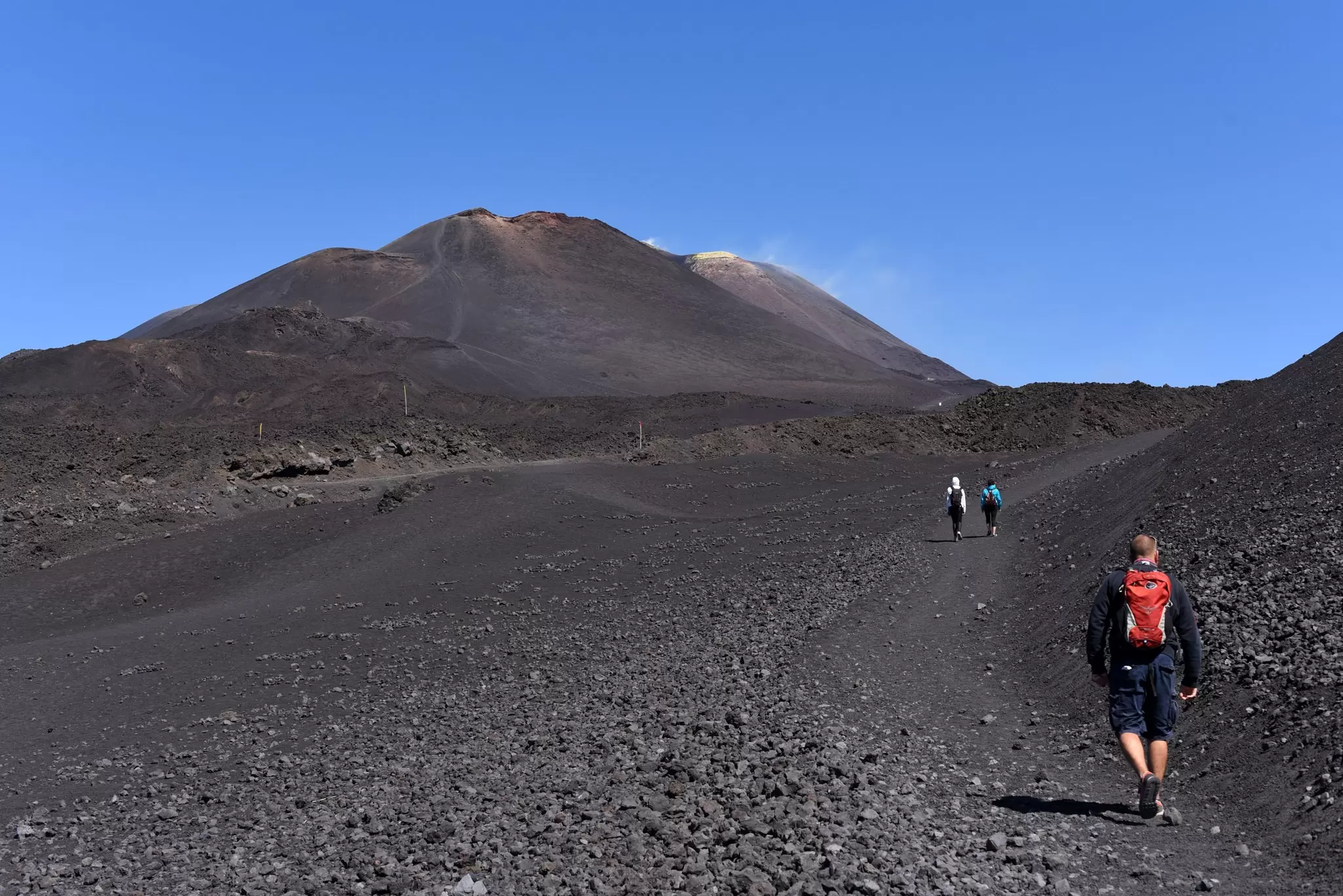 A man hiking on the slope of Mt. Etna, the highest active volcano in Europe.