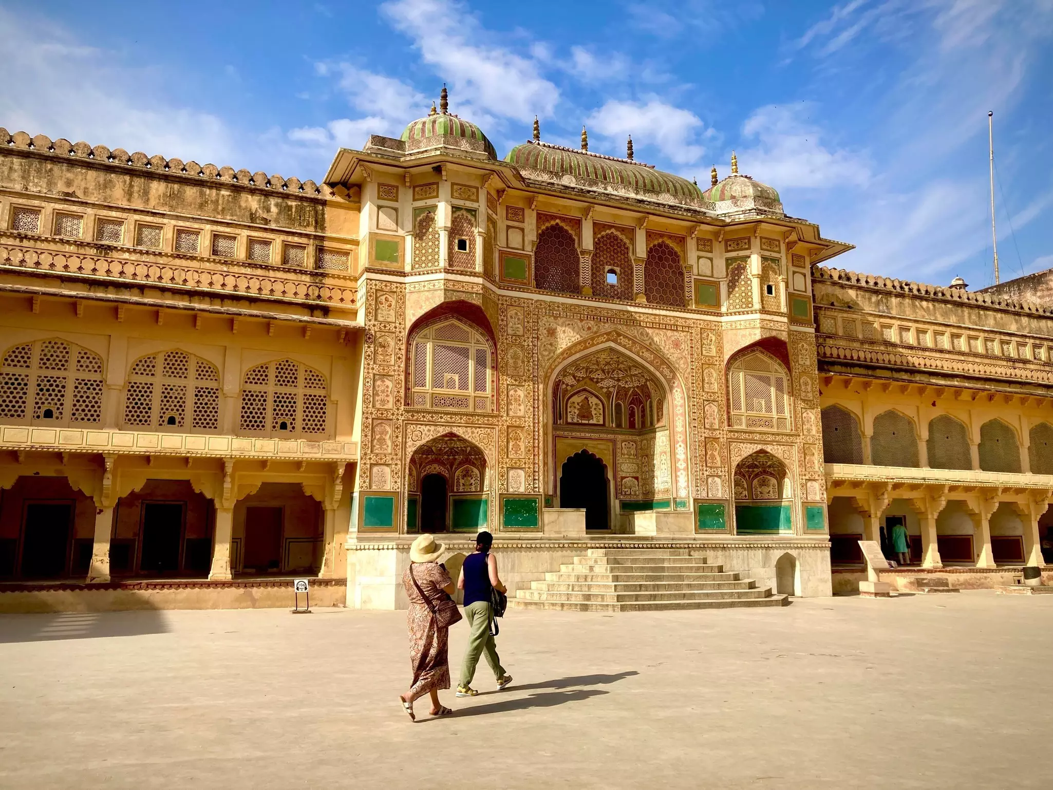 Visitors approach the ornate Ganesh Pol gate at Amber Fort, Jaipur, Rajasthan, India.