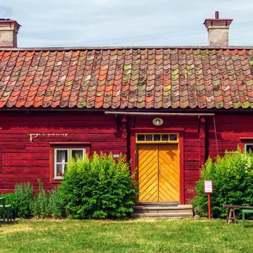 Uppsala, Sweden, June 6, 2018: Red wooden building in Disagarden (Disagården - open air museum of Old Uppsala (70 km from Stockholm). Uppland village in mid-1800s. Front view.  Sunny day., License Type: media, Download Time: 2026-06-09T19:37:52.000Z, User: LP_NZhan, Editorial: true, purchase_order: 65050 - Digital Destinations and Articles, job: App Content, client: Lonely Planet App, other: Nadine Zhan