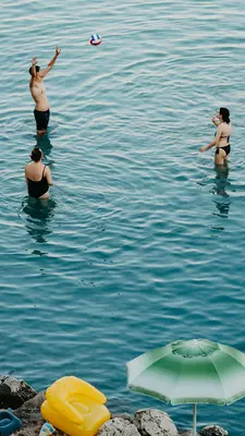 Beach and sea life in "Riviera degli Haethei" beach. 
This beach is called by the locals Spiaggia della Madonna dell'Alto Mare, taking its name from the small church that is located on top of the beach dedicated to Madonna dell'Alto Mare, one of the protectors of the city.

This beach is characterized by crystal clear water and shallow water where you can walk for a long time before reaching the high water. For this reason it is the favorite destination of families with small children, who can swim and play on the shore freely.
On the other side you can see the pier and the port as well as the center of Otranto and its old town.
August 2024: Lecce, Puglia, Italy