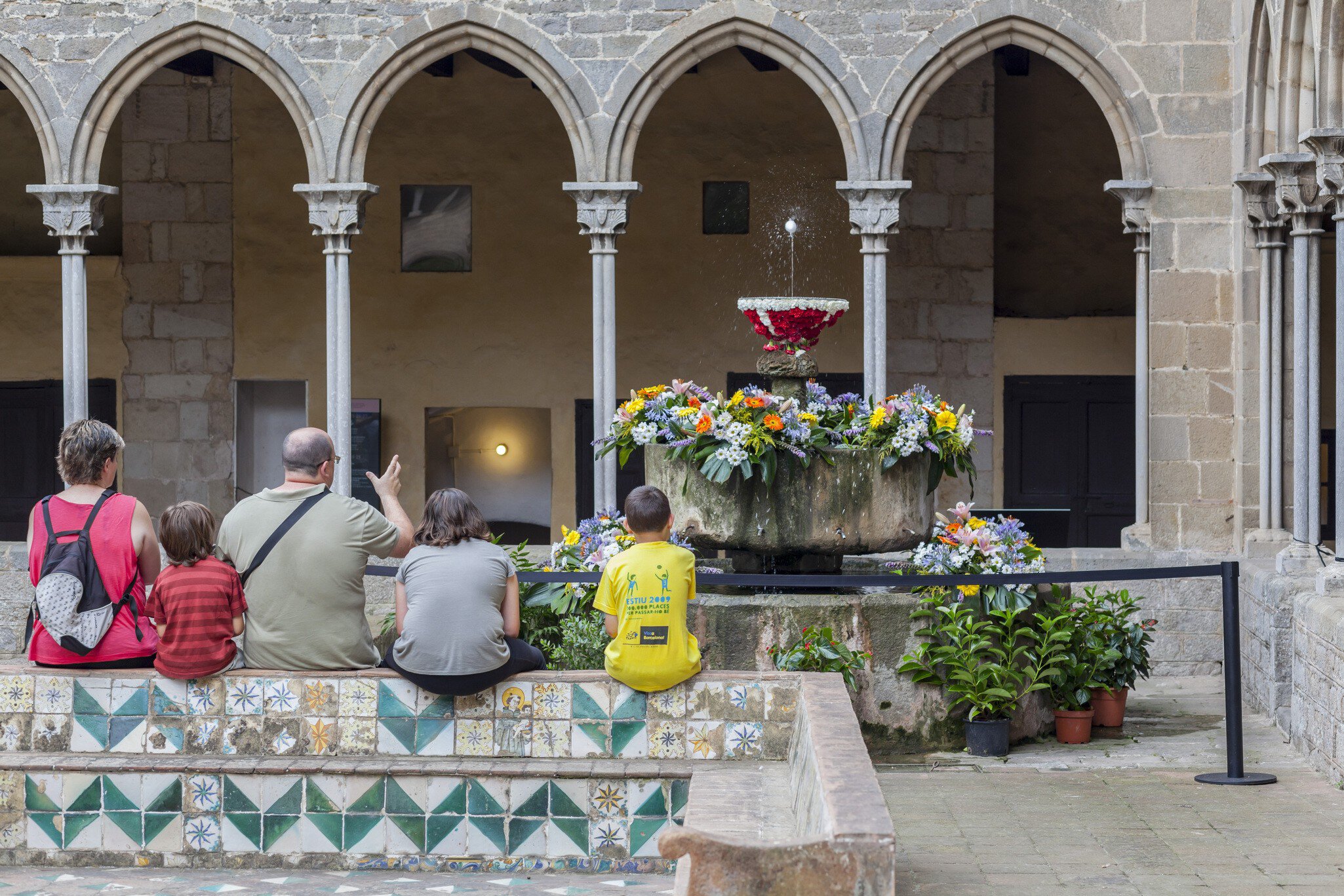 Visitors sit by the cloisters of the Monestir de Pedralbes in Barcelona, Spain.