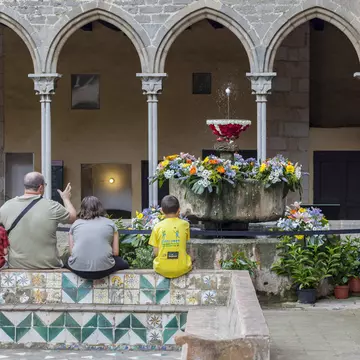 Visitors sit by the cloisters of the Monestir de Pedralbes in Barcelona, Spain.