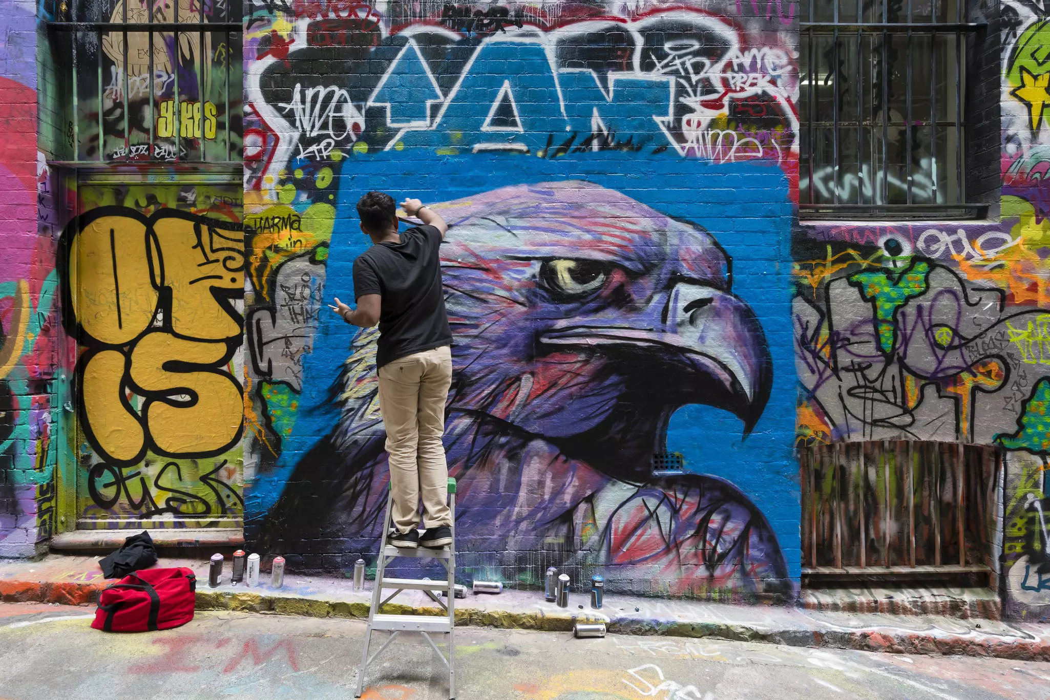Melbourne, Australia: Street artist creating graffiti at Hosier Lane in Melbourne, Australia. Hosier Lane is a laneway in CBD of Melbourne, It is a popular landmark in Melbourne due to its graffitti covered walls and urban art.