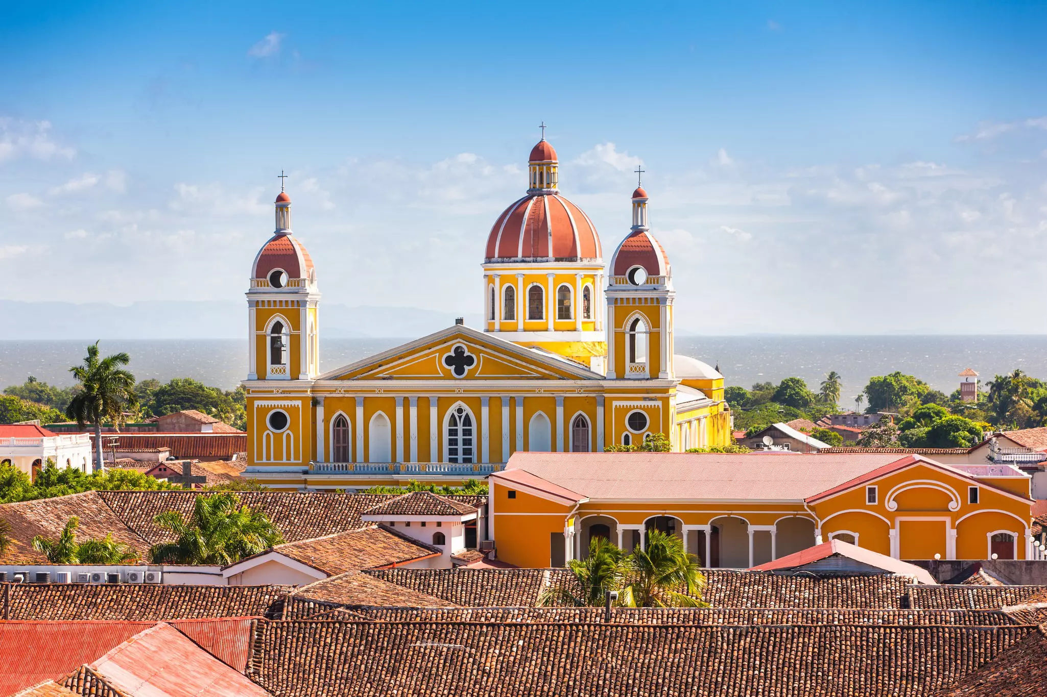 A cathedral with bell towers and a large central dome by the sea