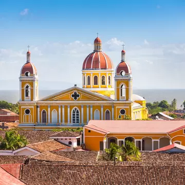 A cathedral with bell towers and a large central dome by the sea