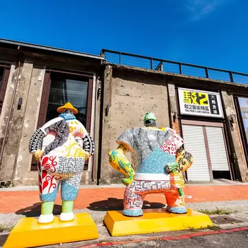 Large colorful, patterned statues stand outside the warehouse buildings of Pier-2 Art Center in Kaohsiung.