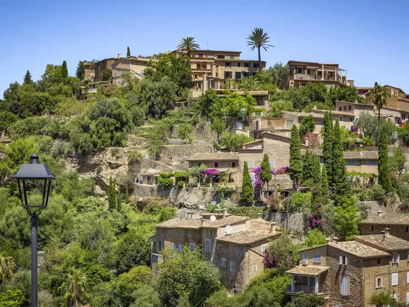 A hilltop village with stone buildings and lush greenery