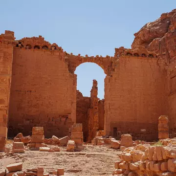 The ruins of the Qasr al-Bint temple in Petra against a blue sky