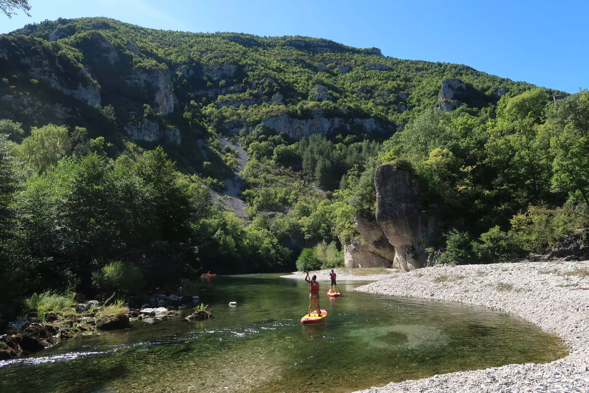 Tourists paddle boarding on the river running through Gorges du Tarn in France