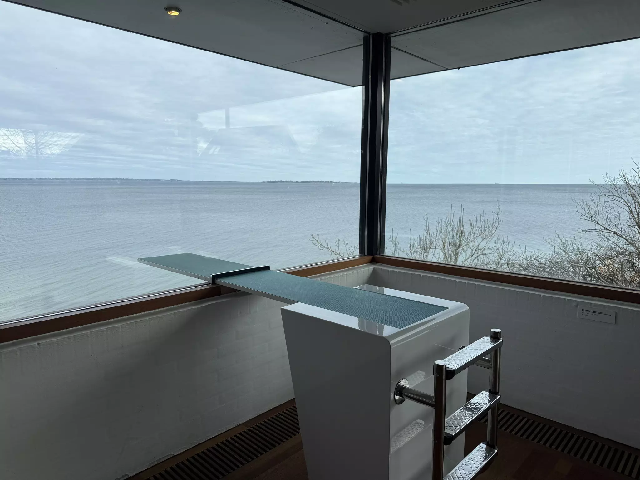 Close-up of art piece called The Panorama Room, a diving board through a glass window, at the Louisiana Museum of Modern Art