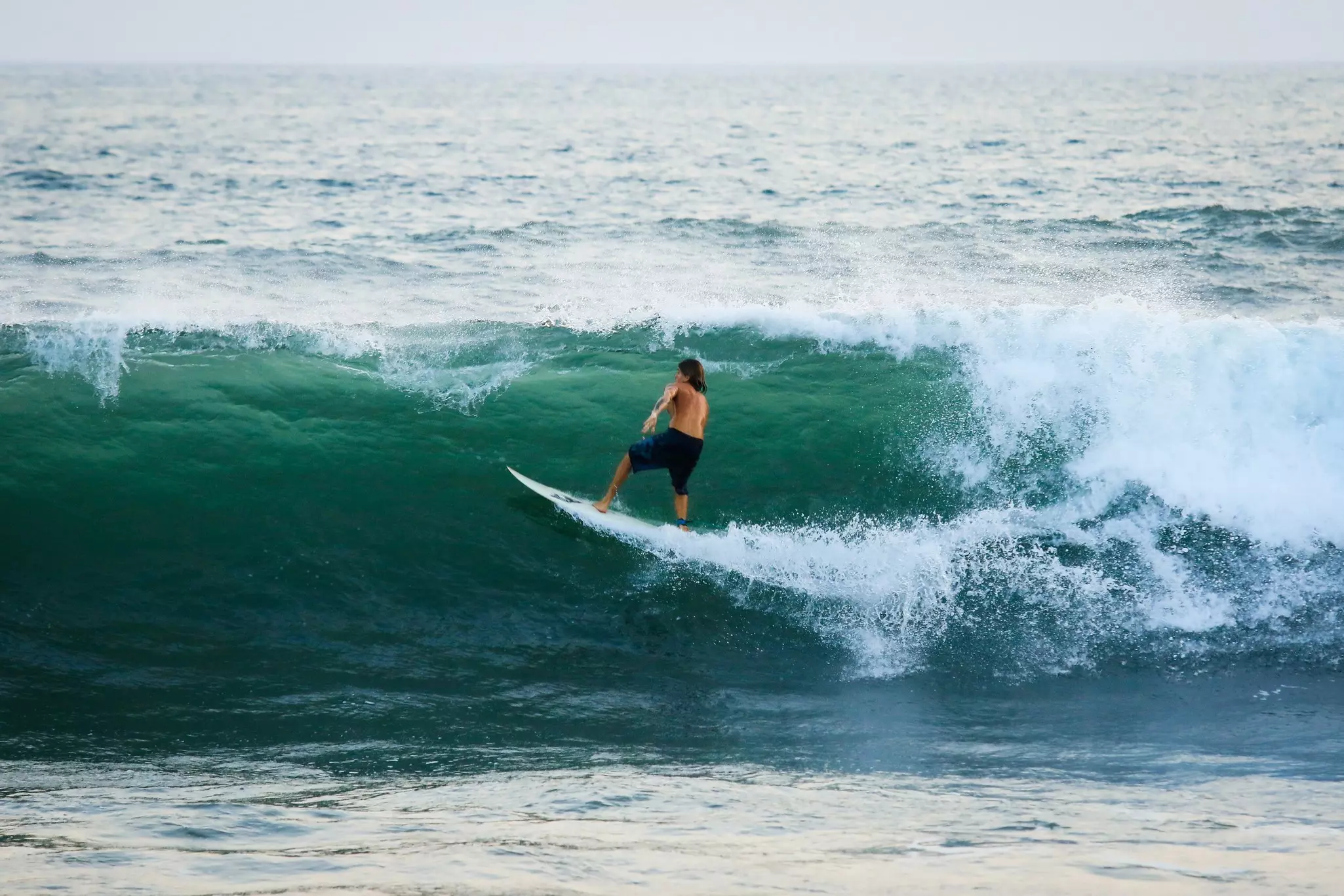A surfer catching a wave at El Tunco, El Salvador.