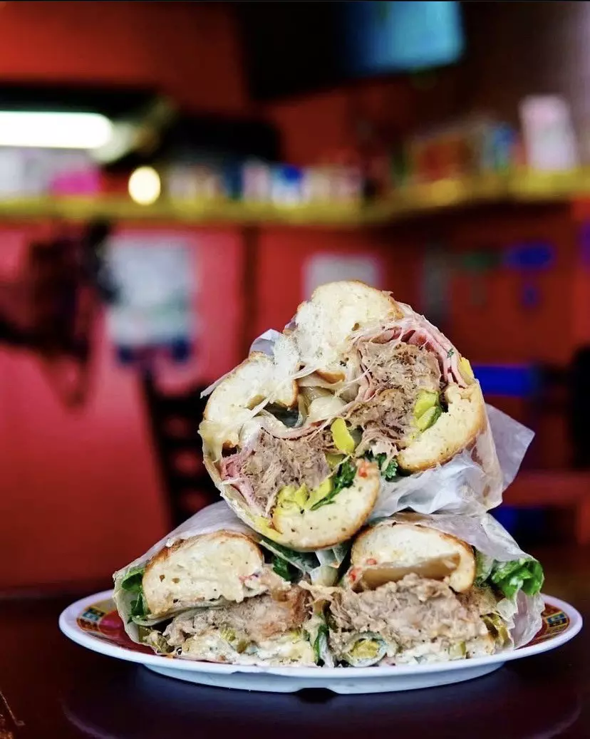 A plated sandwich sectioned into three parts, its contents facing the camera