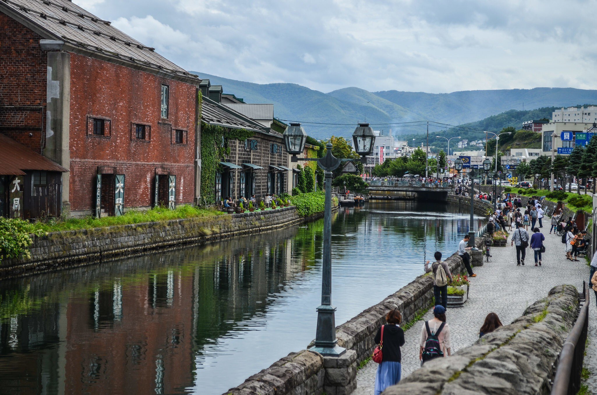 Ivy-covered brick warehouses and gas lamps beside the still water of the Otaru Canal