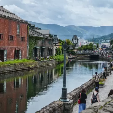 Ivy-covered brick warehouses and gas lamps beside the still water of the Otaru Canal