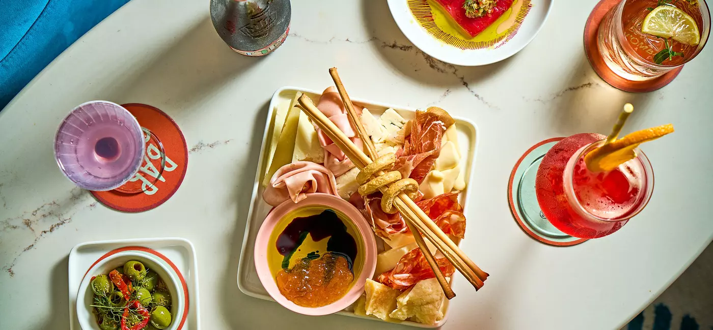 Filled plates of food and glasses with colorful liquids.