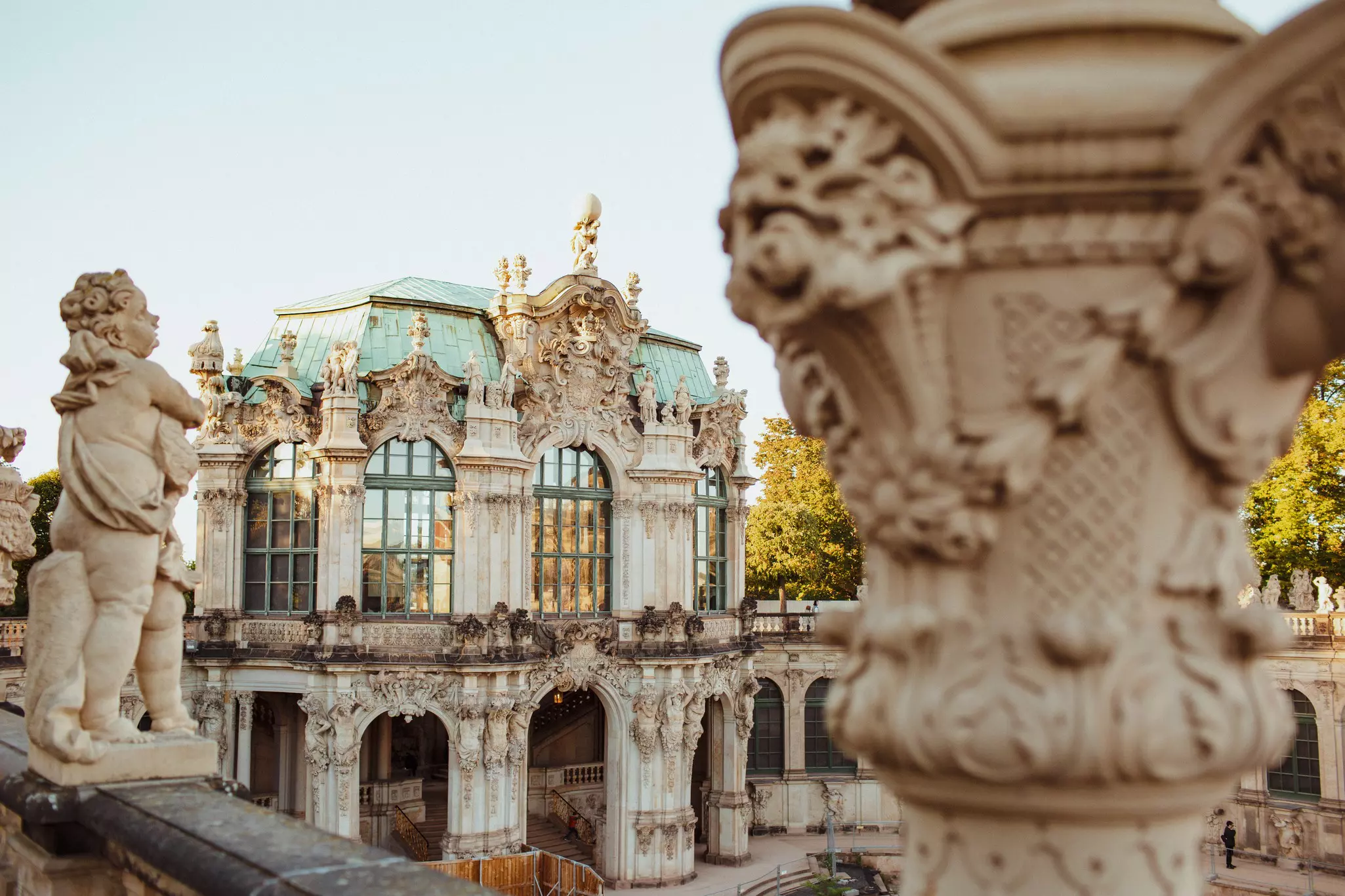 Baroque building with huge glass windows decorated with statues of cherubs.