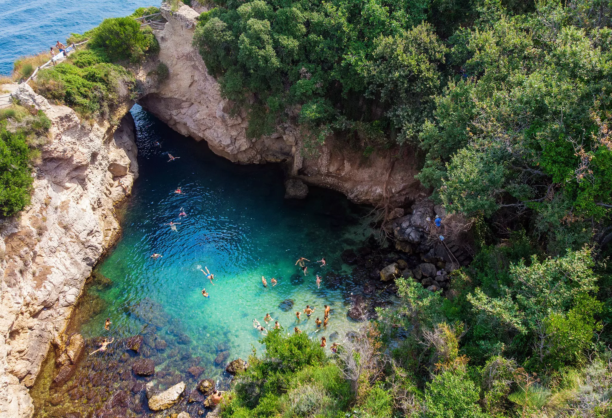 Tourists swimming in crystal clear blue waters of a lagoon