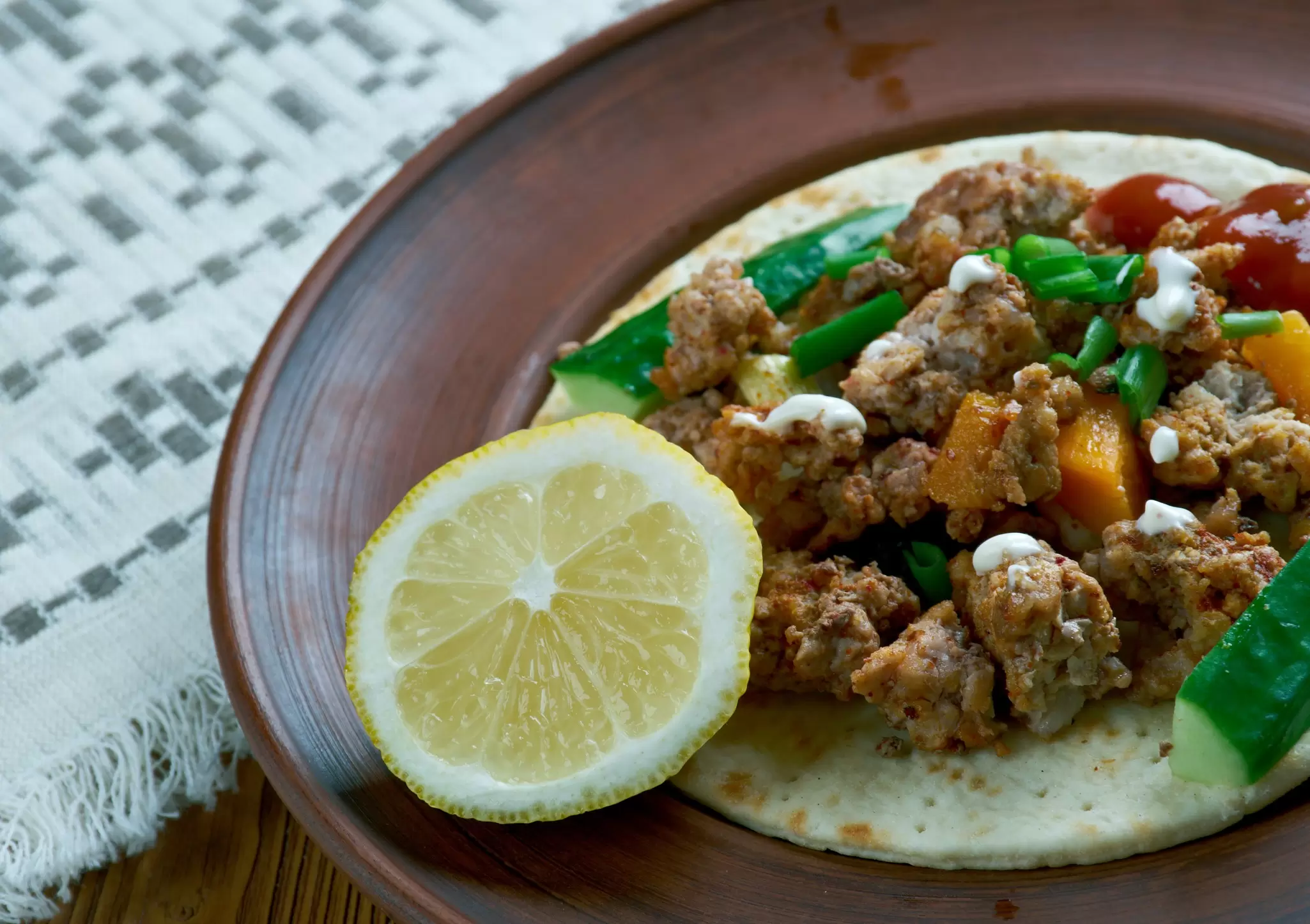 Carne adovada served on a taco, with a wedge of lemon. 