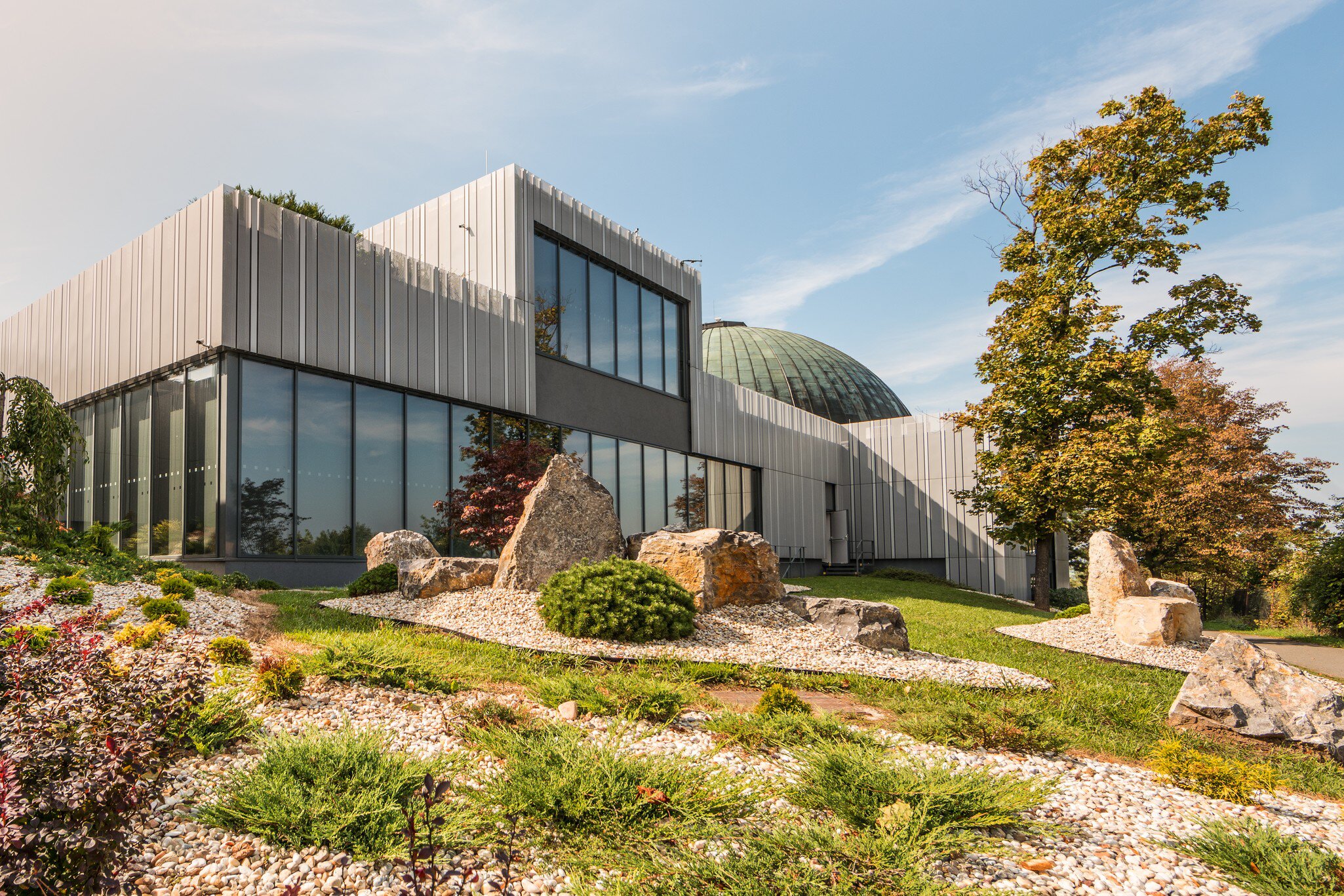 Facade of Brno Planetarium and Observatory with rock-garden. Brno, Czechia. 