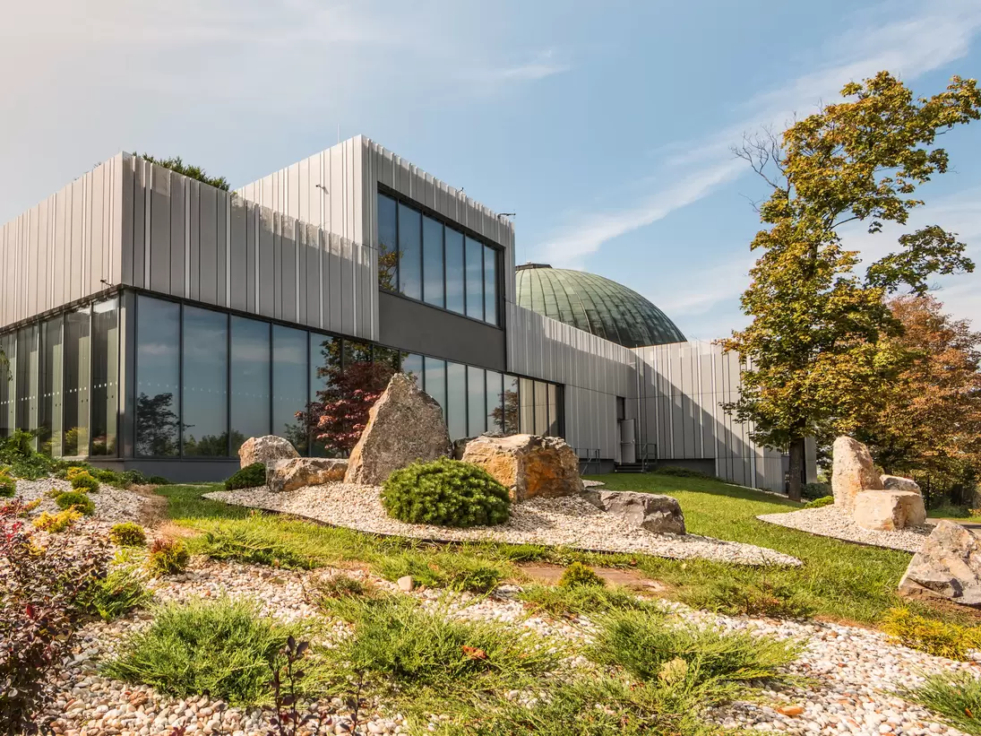 Facade of Brno Planetarium and Observatory with rock-garden. Brno, Czechia. 