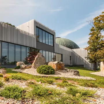 Facade of Brno Planetarium and Observatory with rock-garden. Brno, Czechia. 