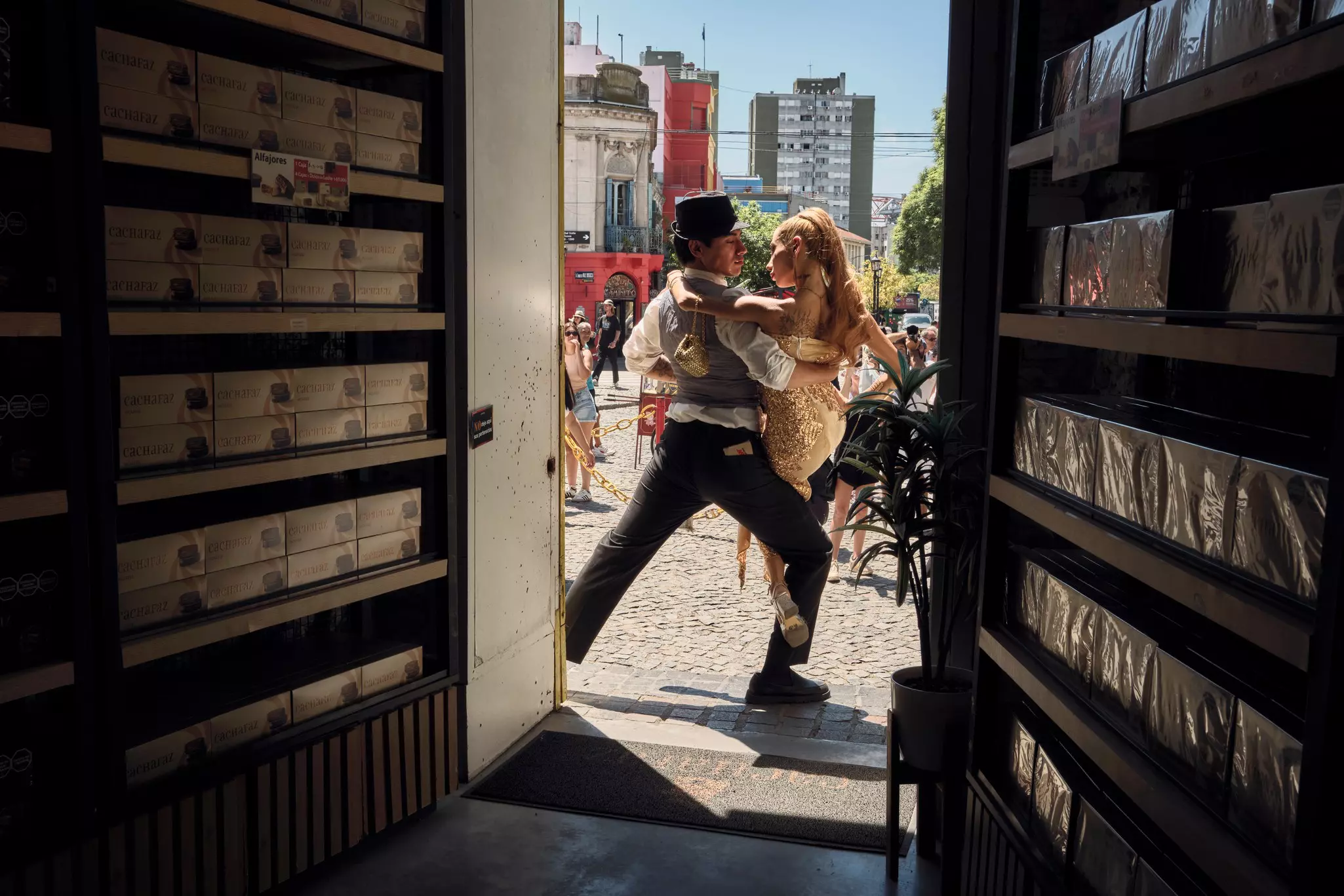 Two tango dancers between a darkened doorway.